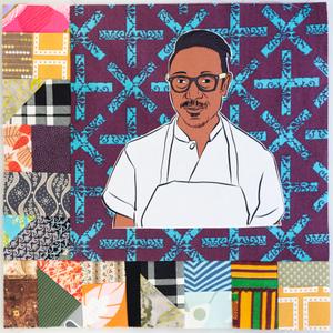 Gregory Gourdet smiling in a white apron.