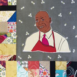 Arthur Davis smiling in a red apron.