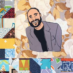 Warren Luckett smiling in a grey suit jacket.