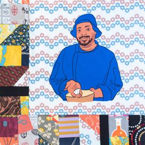 BJ Dennis in a blue chef coat smiling and holding food in his hands.