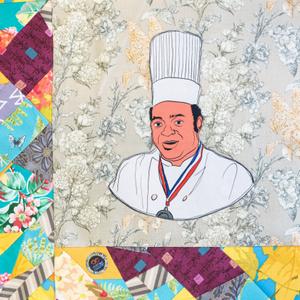 Stanley Jackson smiling in a white chef coat and wearing an award medal.