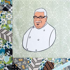 Leon West smiiling in a white chef coat.