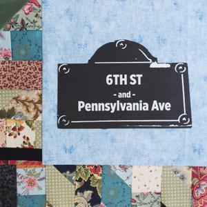 A black sign that reads "6th St and Pennsylvania Ave".