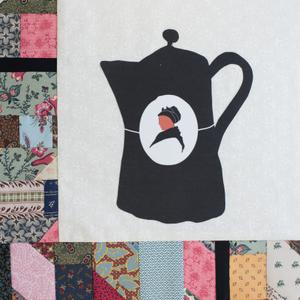 A black coffee poat with a woman's face.