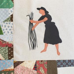 An African American woman handling rice in a field.
