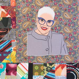 Deborah VanTrece smiling in a gray chef coat.